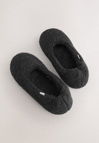 Pantofole nere in lana con superficie morbida e testurizzata, punta arrotondata e aperture elastiche per il comfort. Design minimalista con una piccola etichetta.