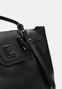 Borsa in pelle nera con finitura testurizzata, presenta una fibbia in argento e un dettaglio del logo stampato. Include una tracolla rimovibile.