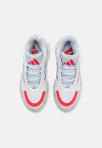 Baskets de sport blanches avec une tige en mesh, accents rouges et détails argentés. Caractéristiques : un col rembourré et des lacets plats.