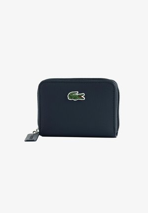 Portefeuille zippé texturé noir avec un logo crocodile vert et une petite languette rectangulaire sur la fermeture éclair.
