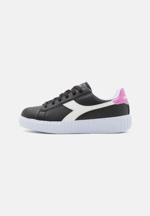 Sneaker sintetica nera con accenti bianchi, punta arrotondata, suola piatta bianca e un tallone rosa e bianco. Presenta lacci neri e dettagli perforati.