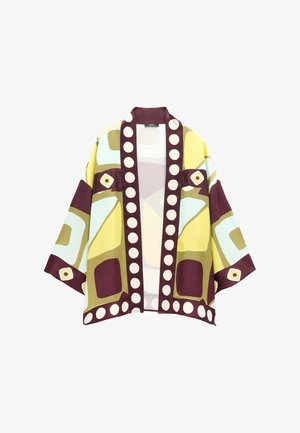 Krótka kurtka z szerokimi rękawami, ozdobiona geometrycznymi wzorami w kolorach żółtym, zielonym, burgundowym i kremowym, z dużymi kremowymi kropkami na bordowych brzegach.