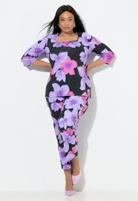 Mehrfarbiges Blumenoutfit mit schwarzer Basis; mit violetten und pinken Blumen. Dreiviertelärmel und quadratischer Ausschnitt am Oberteil.