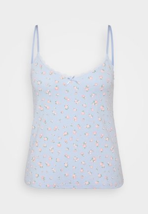 Camisole bleu clair à fines bretelles, ornée d'un motif floral en rose et vert, avec une bordure en dentelle festonnée et un petit nœud bleu au niveau du col.