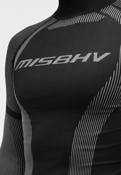 Μαύρο συμπιεστικό τοπ με ψηλό γιακά, υφή υφάσματος και δυναμικό γκρι ριγέ μοτίβο. Το λογότυπο "MISBHV" εμφανίζεται έντονα.