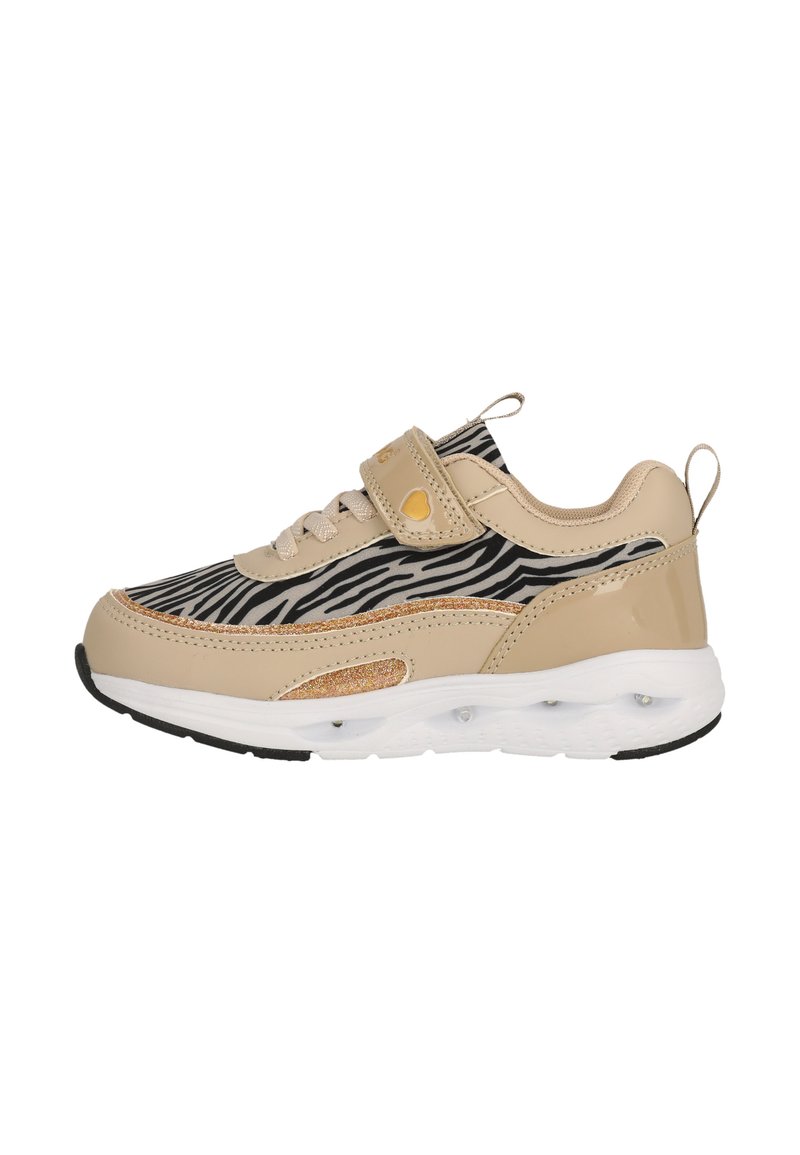 Baskets beige avec imprimé zèbre noir et blanc, bande Velcro et accents pailletés. Semelle intermédiaire blanche avec des capsules de cushioning transparentes et semelle extérieure noire.