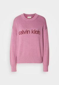 Pull en maille violet clair à manches longues avec col, poignets et ourlet côtelés, avec le texte "calvin klein" en violet plus foncé sur la poitrine.