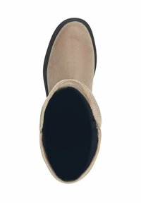 Botină din suede bej până la gleznă, cu vârf rotund, talpă din cauciuc negru și textură moale. Interiorul este întunecat, fără modele sau accesorii vizibile.