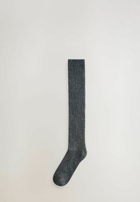Yksittäinen tummanharmaa polvensuun sock, jossa on raidoitettu pinta ja valkoisia täpliä, asetettuna litteäksi vaaleanharmaalle pinnalle.