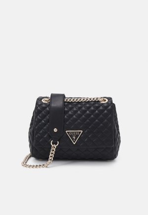 Sac à main en cuir noir matelassé avec une bandoulière chaîne dorée et un logo triangulaire Guess USA sur le rabat avant.