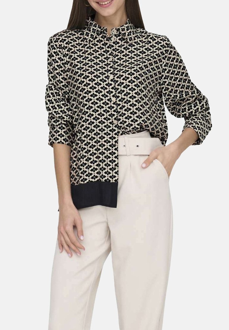 Chemise à boutonner crème et marine avec un motif géométrique. Dispose d'un col, de manches longues et d'un ourlet inférieur uni marine. Texture lisse.