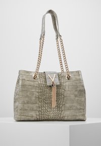 Krokodilprägling ljusgrön handväska med guldfärgade kedjehandtag, tofsdetalj och rektangulärt lås med ett V-logotyp.