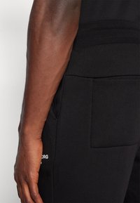 Björn Borg ESSENTIAL PANTS - Treniņtērpa apakšdaļas - black beauty