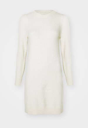 Kremfarget strikket kjole med lange ermer, ribbestrikkede mansjetter og et teksturert mønster gjennom hele; rund halslinning og kanten faller over kneet.