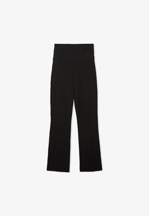 Pantalones de yoga negros y acampanados hechos de un tejido elástico. Cintura alta, textura suave, sin patrones visibles ni detalles de hardware.