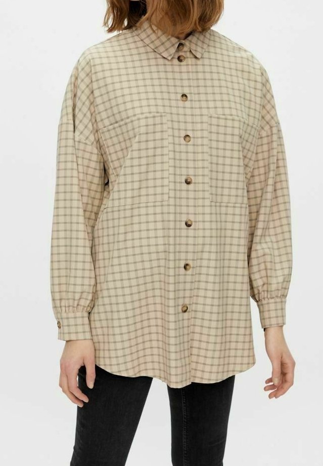Beige rutmönstrad skjorta med krage, långa ärmar och knäppning fram. Har två bröstfickor och en rundad nederkant, tillverkad av ett mjukt material.