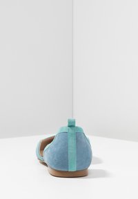 Niebieskie zamszowe baleriny z kontrastującym turkusowym uchwytem na pięcie i wykończeniem. Gładka tekstura i zaokrąglony kształt, zaprojektowane do łatwego zakładania.