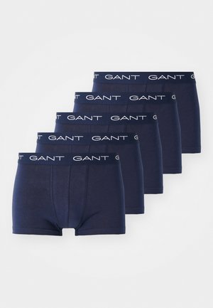 Cinq paires de boxer bleu marine fabriqués dans un tissu lisse, avec une taille élastique blanche sur laquelle est imprimé en répétition "GANT".