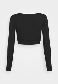 Top lungo a maniche lunghe nero, a coste, corto, con un ampio scollo e silhouette aderente. Tessuto liscio con dettagli di cucitura all'orlo.