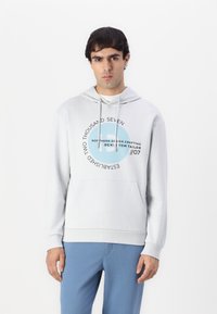 Hoodie gris claro con cordones, bolsillo canguro frontal y una impresión gráfica circular en texto azul y negro en el pecho.
