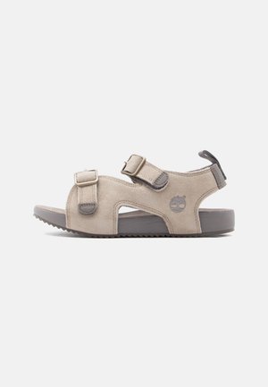 Bézs színű velúr szandál két állítható csattal, szürke talppal és sarokhúzóval, oldalán fa logóval.