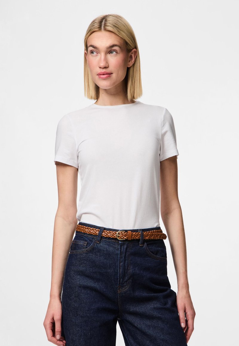 Wit T-shirt met korte mouwen en een ronde hals, gedragen met donkerblauwe spijkerbroek met een gevlochten bruine riem. Glad stof en een aansluitend ontwerp.