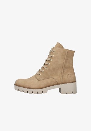 Bottines beiges à lacets fabriquées en daim, avec un bout arrondi, une surface texturée et une semelle blanche épaisse avec un léger talon.