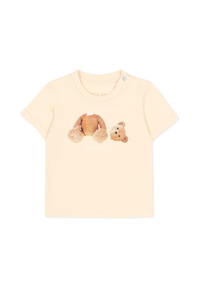 T-shirt beige pour tout-petit avec un motif d'une tête et d'un corps d'ours en peluche détachés sur le devant et un bouton pression à l'épaule.
