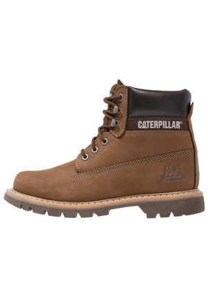 Brauner Leder-Caterpillar-Arbeitsschuh mit gepolstertem schwarzem Kragen, Metallösen und dicker Gummisohle mit tiefem Profil.
