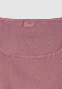 Ριμπ πουκάμισο σε ροζ χρώμα με στρογγυλεμένο ντεκολτέ. Φέρει κεντρική ετικέτα με την ένδειξη "Levi's" και ραμμένες πληροφορίες μεγέθους στο εσωτερικό.