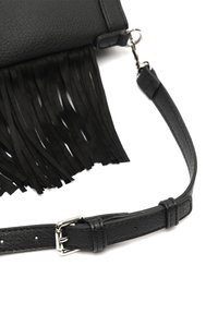 Sac à main en cuir noir avec des franges longues. Bandoulière ajustable avec une boucle en argent. Surface texturée qui accentue l'intérêt visuel.