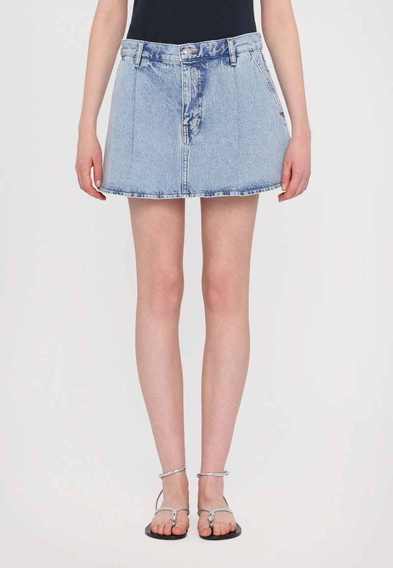 Denim skirt in light blue, A-line shape, featuring a button and zipper closure, with a faded wash and subtle whiskering at the front.