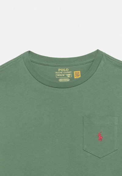 Πράσινο μπλουζάκι με στρογγυλή λαιμόκοψη και μπροστινή τσέπη που διαθέτει ένα μικρό κόκκινο κεντητό λογότυπο παίκτη πόλο και ετικέτα μεγέθους μέσα στον γιακά.