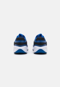 Des chaussures de sport bleues et noires avec une tige en maille respirante, un col rembourré et une semelle intermédiaire blanche avec des détails texturés sur la semelle.