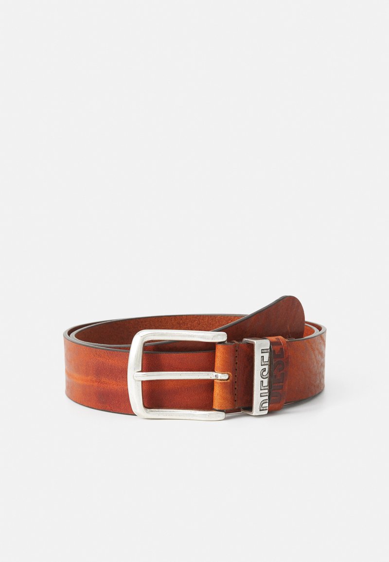 Ceinture en cuir marron avec une boucle en métal argenté. Possède une finition texturée et un logo embossé sur le passant. La largeur est standard pour les ceintures.