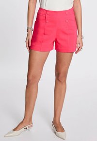 Shorts taillés rose vif avec une taille haute et deux boutons décoratifs à l'avant. Fabriqués à partir d'un tissu tissé lisse.
