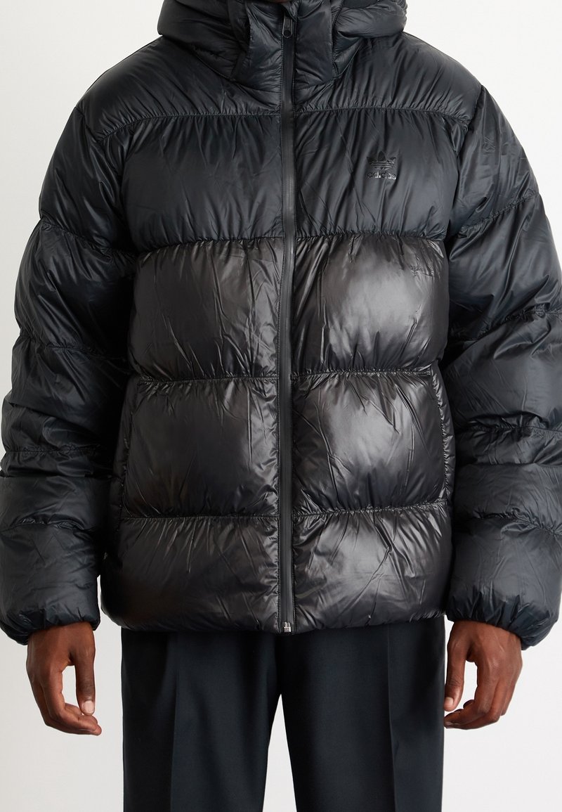 Black puffer jacket with a shiny finish, featuring a hood, zip closure, and horizontal quilted design. Material appears lightweight and insulated.