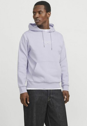 Sweat à capuche en coton lavande avec poche frontale, cordon de serrage, poignets et ourlet côtelés. Présente un texte logo subtil sur la poitrine. Associé à un jean foncé.