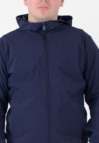 Giacca con cappuccio blu navy realizzata in materiale leggero, dotata di una zip centrale e due tasche laterali. Texture liscia con dettagli minimi.