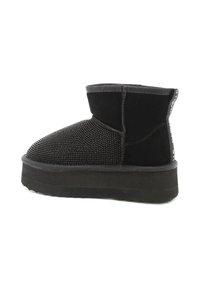 Stivale nero alla caviglia con tomaia texturizzata caratterizzata da piccoli rivetti neri, una suola liscia nera a contrasto e design a punta rotonda.