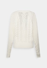 Krämfärgad tröja med kabelstickat mönster, med långa ärmar och ribbat avslut. Baksidan visar ett intrikat texturmönster.