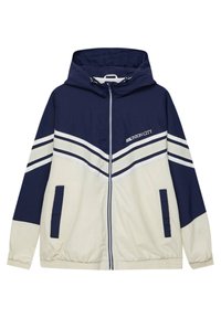 Veste coupe-vent bleu marine et beige avec capuche, fermeture éclair frontale, deux poches latérales, bandes blanches sur les manches et texte "Union City" sur la poitrine.