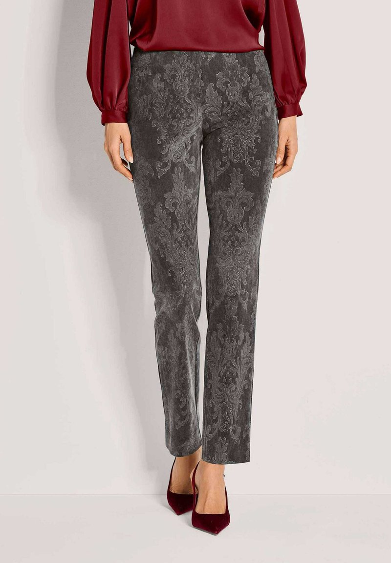 Grijs patroonbroek met een fluweelachtige textuur, voorzien van een sierlijk ontwerp en een slanke snit, gecombineerd met rode hoge hakken en een bordeaux blouse.