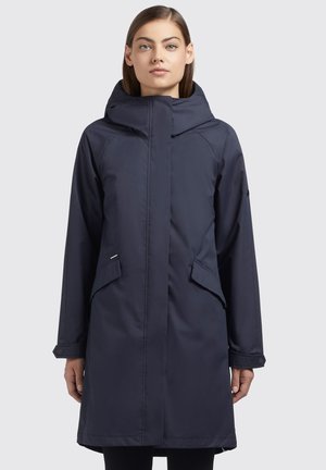 Parka imperméable bleu marine avec un col haut, fermeture éclair à l'avant, poches latérales et poignets boutonnés. Tissu lisse, légèrement brillant avec une coupe décontractée.
