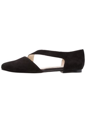 Zapato plano de ante negro con punta en pico y tiras laterales recortadas, tacón bajo y forro interior beige.