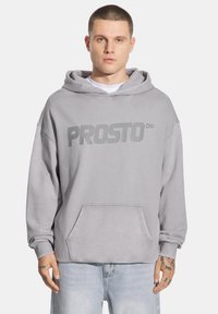 Szara bluza z kapturem o luźnym kroju, z dużą kieszeni�ą kangurką oraz napisem "PROSTO∞" na piersi. Wykonana z miękkiego materiału o teksturowanym wykończeniu.