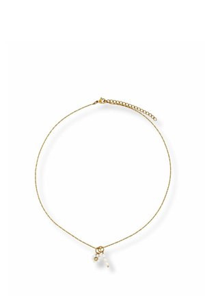 Delicate gold chain necklace with a clasp and three small pendant charms, including a white flower and bead details.