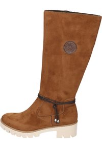 Brown suede knee-high boot with a textured finish, featuring a logo patch and a decorative tied cord around the ankle. Chunky white outsole.