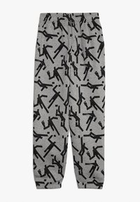 Szare dresy z odważnym, abstrakcyjnym czarnym wzorem. Miękka tkanina z elastycznym pasem na wygodę i luźny krój.