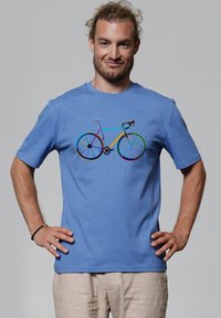  Lichtblauwe katoenen t-shirt met een multikleurige fietsafbeelding op de voorkant. Korte mouwen en een ronde halslijn.
